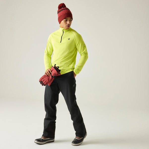 Full-length lifestyle view of Dare2b Achieve III black ski trousers worn with winter boots
