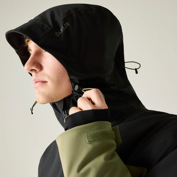 Model adjusting hood on Dare2b Halfpipe IV Olive and Black waterproof ski jacket
