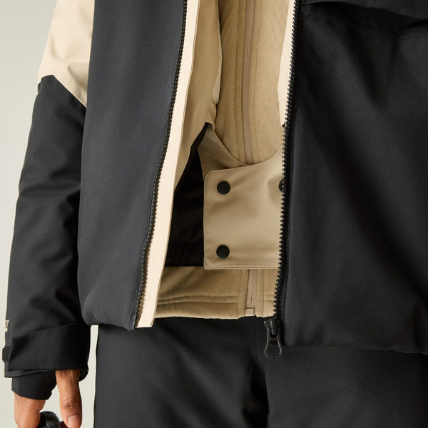 Close-up of a person wearing a black and beige color-blocked jacket, showing the front zipper, snap-button placket, and fabric texture.