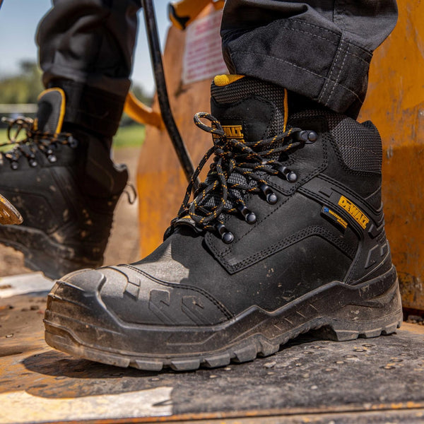 DeWalt Bedrock black safety boots worn on a construction site.