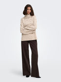 Model wearing JDY Sabine Oatmeal cowl neck knitted jumper with dark trousers
