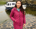 Woman wearing Lighthouse Laurel Berry coat by a harbour