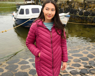 Woman wearing Lighthouse Laurel Berry coat by a harbour