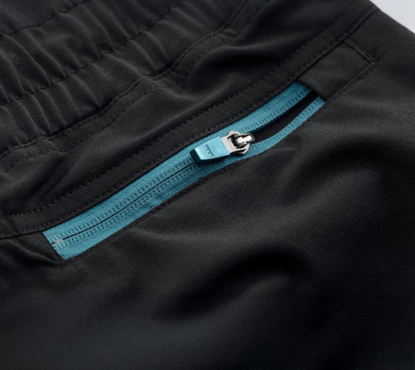 Close-up of black joggers with a blue zipper pocket