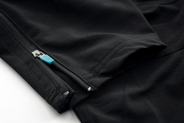 Close-up of a black trouserst with ankle zipper on a white background