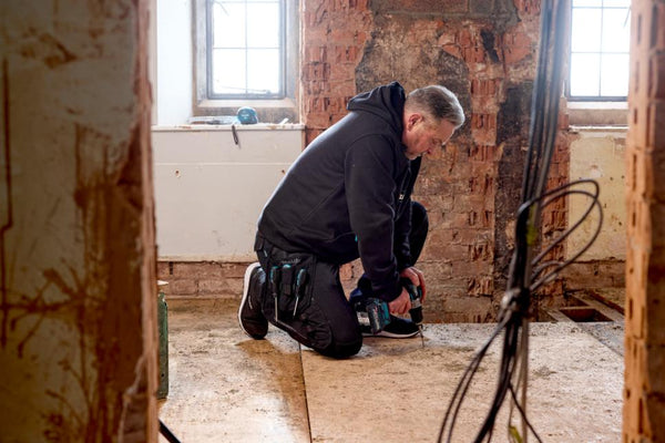 Joiner wearing Makita Onyx Stretch Trousers MK304M slim fit work trousers with holster pockets