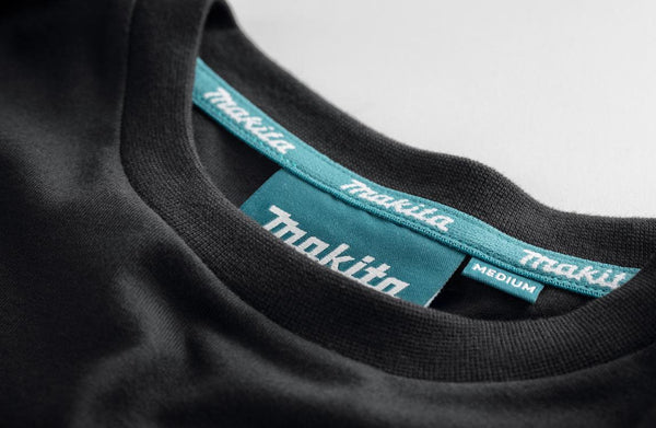 Close-up of black t-shirt with 'Makita' branding on the collar and label.