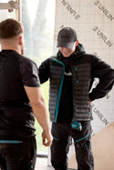 Two workers in a construction setting wearing Makita workwear