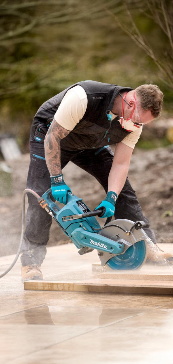 Builder using a circular saw on a wooden surface outdoors wearing a makita shield work bodywarmer