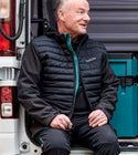 Man sitting on a vehicle wearing a black jacket with 'makita' branding.