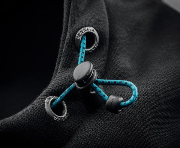 Close-up of black and teal buttons on a dark fabric background