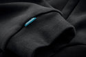 Close-up of a black sweater with a blue 'makita' label.
