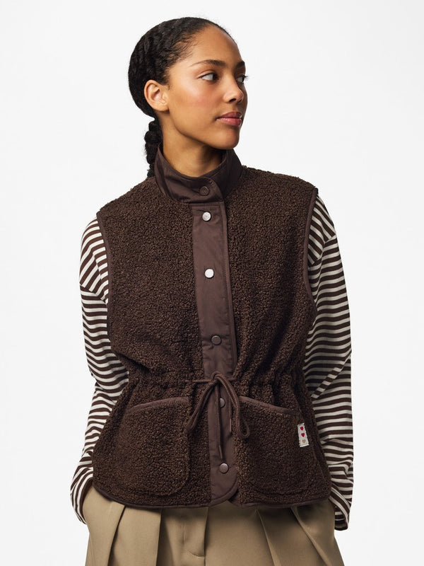 Model wearing PIECES Katty Hot Fudge teddy gilet with striped top and adjustable drawstring waist

