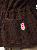 Close-up of Hot Fudge PIECES Katty teddy fleece gilet showing plush texture, front pocket and heart label
