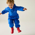 Child jumping in Regatta Splosh III Oxford Blue waterproof suit